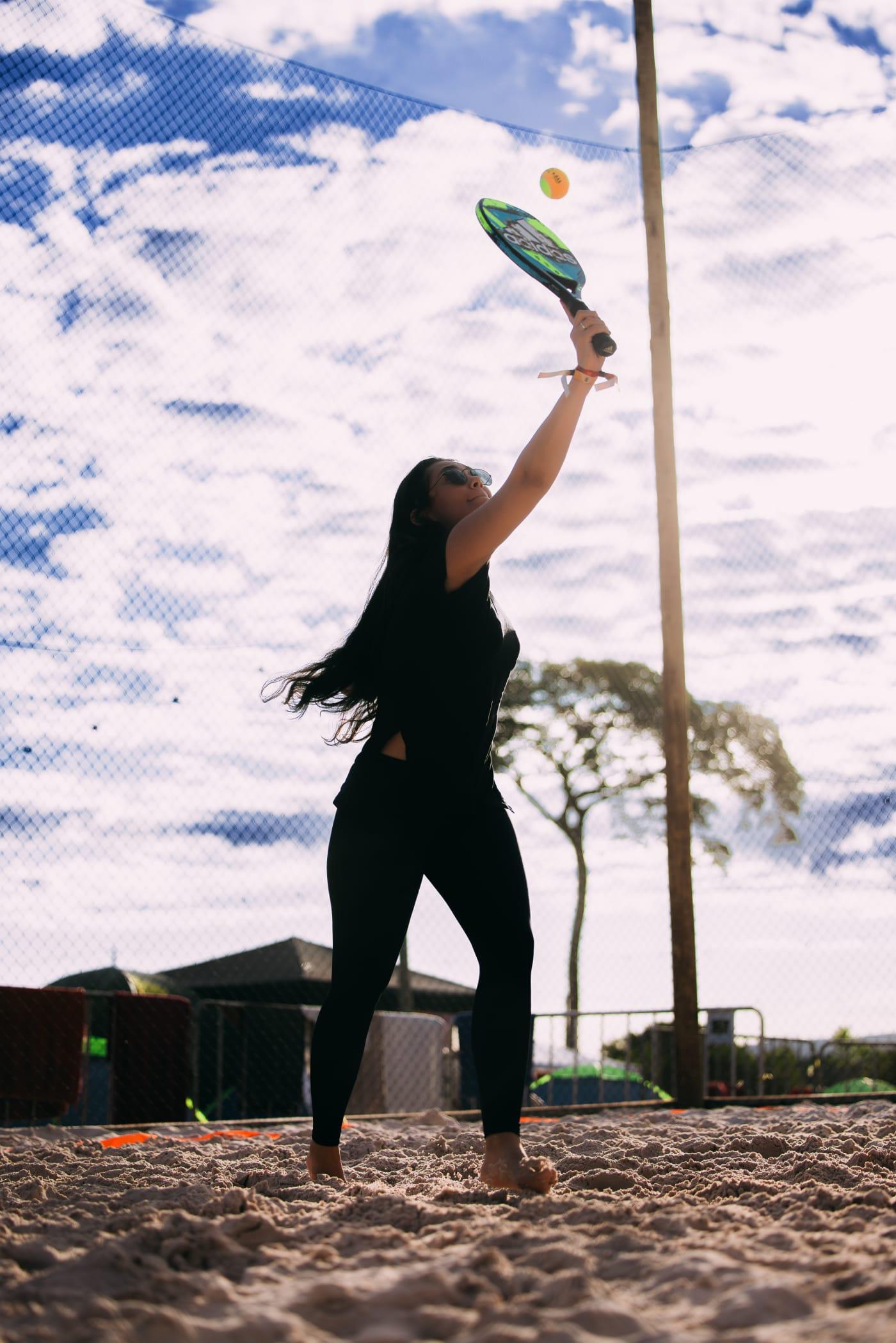 Pessoa praticando frescobol no camping STL Valley em dia ensolarado, aproveitando as atividades esportivas ao ar livre